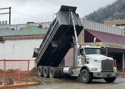 Sutco Transportation Specialists Tridem Dump Truck Delivering to Construction Site